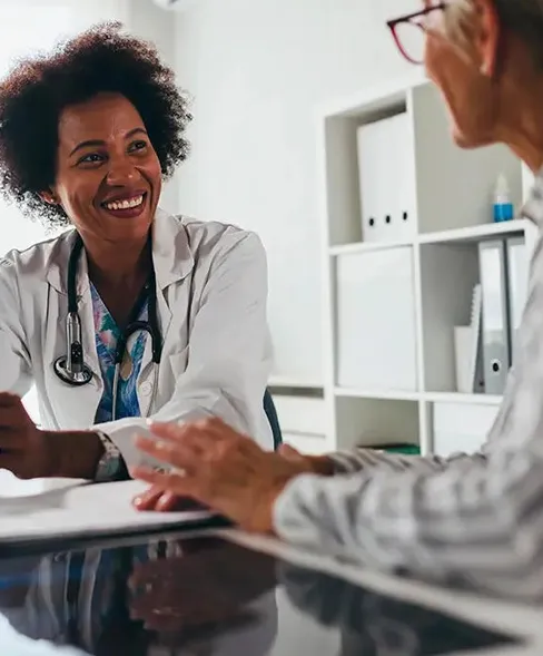 A smiling healthcare practitioner 
                        consulting with her patient
